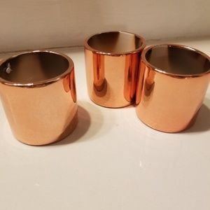 Three small metallic rose gold planter pots